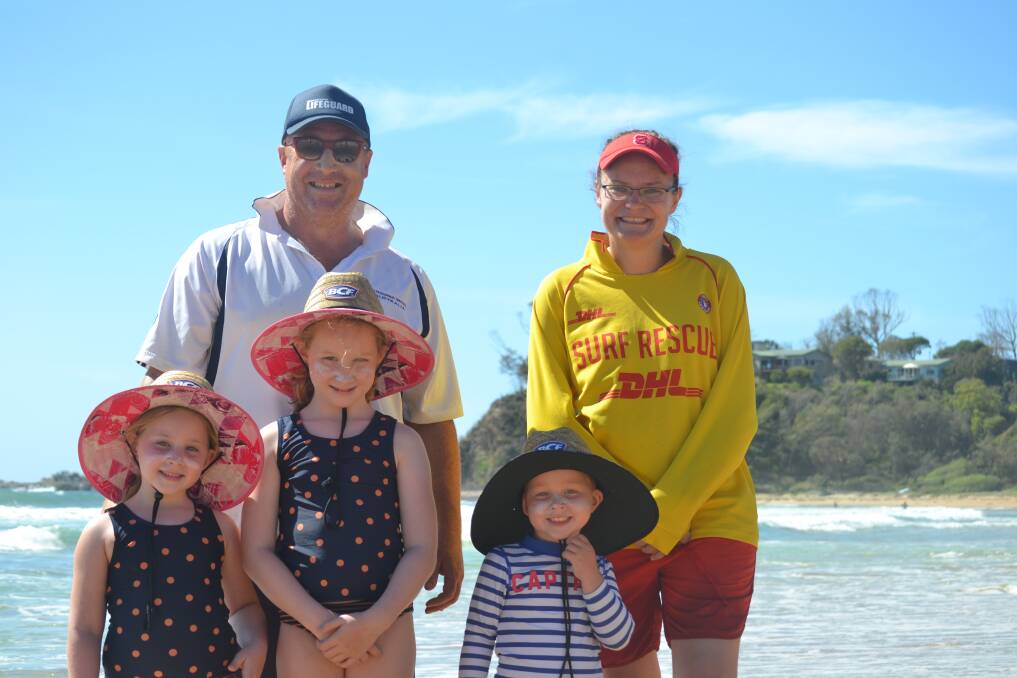 Lifeguard Stan Wall with his children Amelia, Maddison and Edward, and Batemans Bay Surf Lifesaver Helen Smith after demonstrating how quickly biodegradable dye can move in a rip at Rosedale on January 23, 2021.