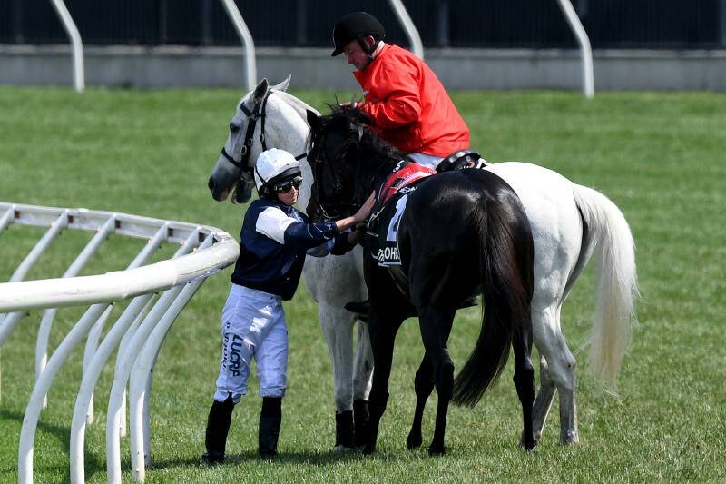 Jockey Aiden O'Brien on The CliffsofMoher is assisted by a race steward. Photo: AAP, Dan Himbrechts