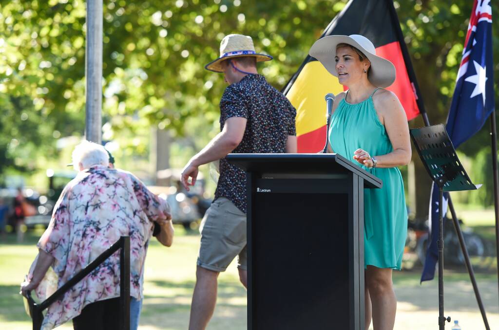 Stage managed: Marie Elliot is assisted off stage by Wodonga councillor Danny Lowe as mayor Annie Speedie addresses the Australia Day gathering. Picture: MARK JESSER