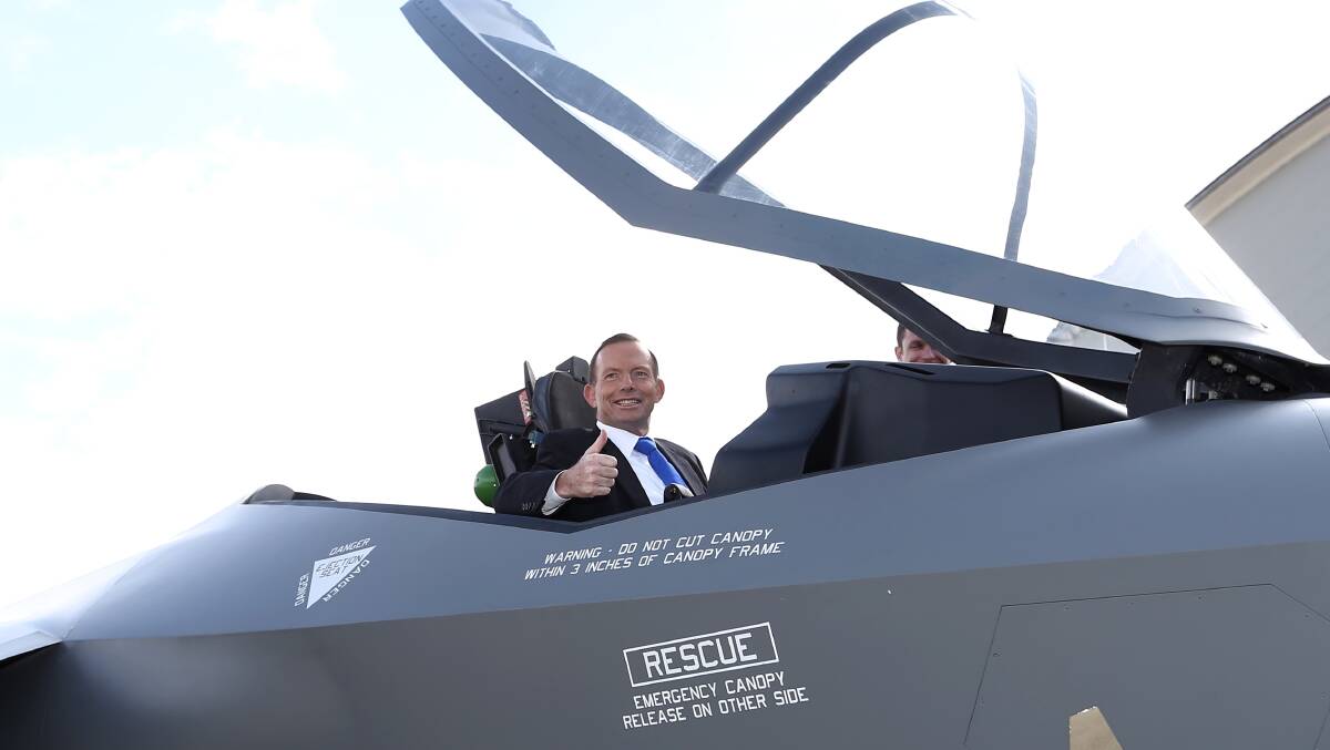 Former prime minister Tony Abbott poses for photos from the cockpit of a replica of a F-35A Lightning II Joint Strike Fighter, at Fairbairn, in Canberra in 2014. Picture: Alex Ellinghausen