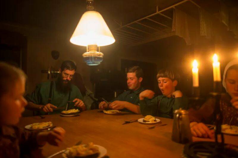 The McCallum family sits down to dinner by candlelight and kerosene lamp. Picture:MEREDITH O'SHEA