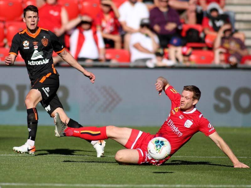 Ryan Kitto of United gets to the ball before Jake McGing of the Roar in their A-League clash.