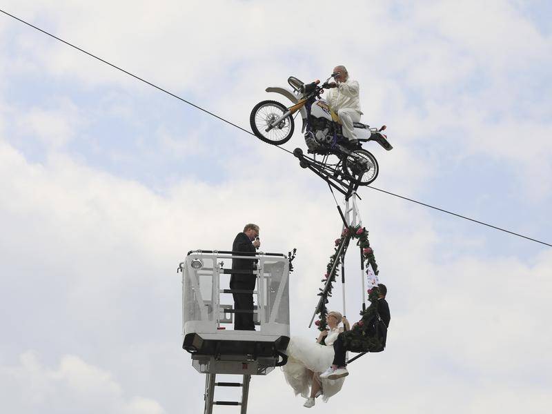 A couple in eastern Germany have married in a mid-air ceremony, dangling from a bike on a tightrope.