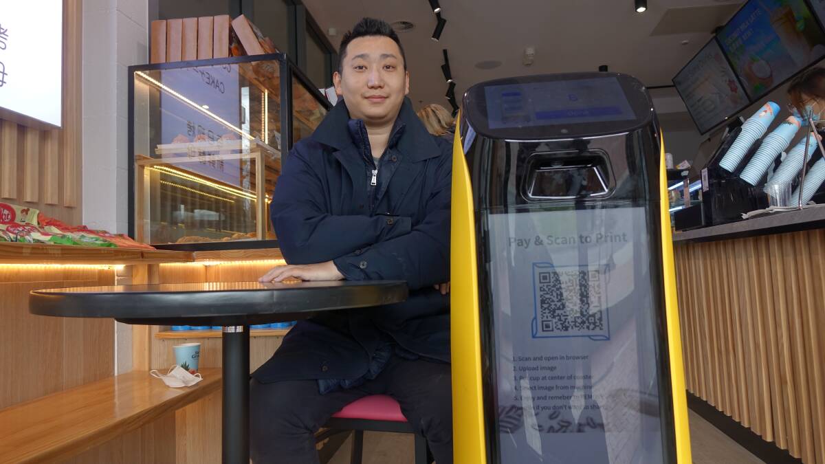 Jack Wang of the Hakko Bakery Cafe in Canberra and the robot which delivers the coffee. Picture: Steve Evans